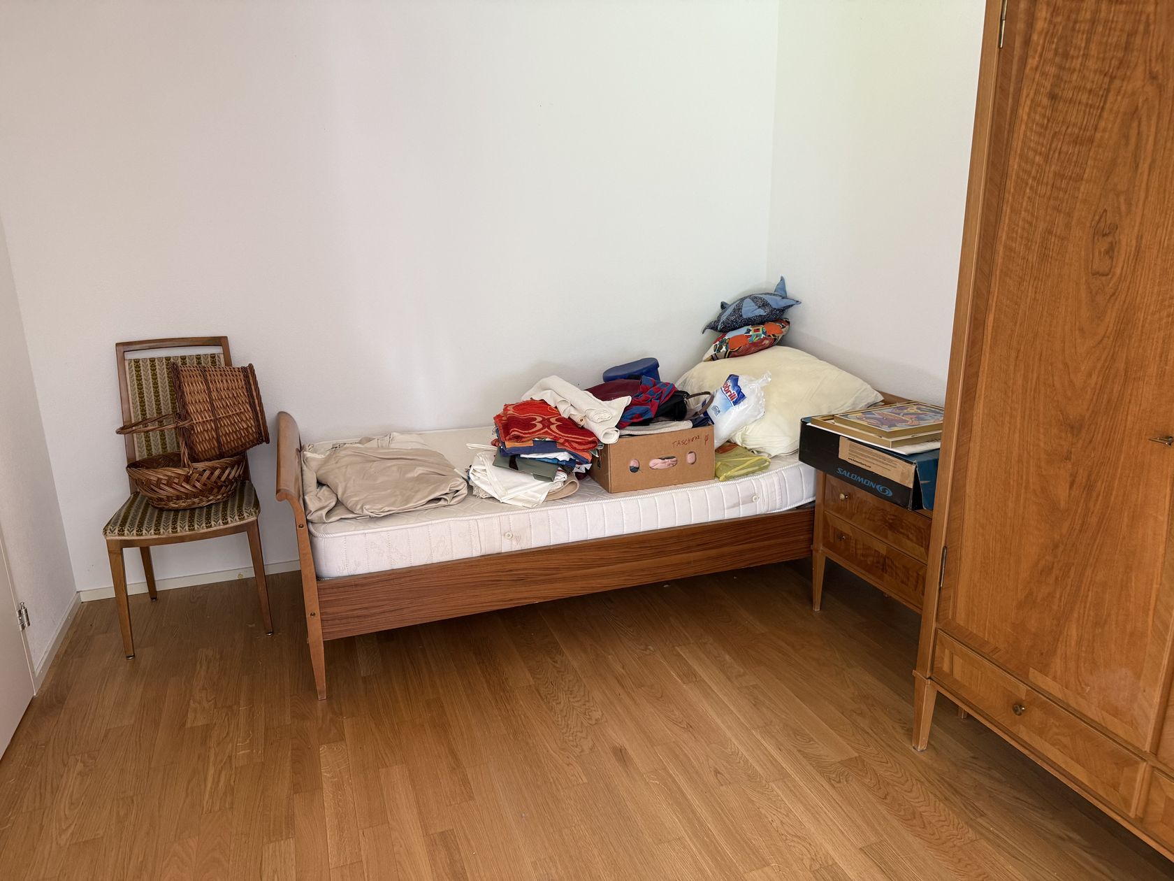 Schlafzimmer mit Bett und Umzugskartons vor der Räumung