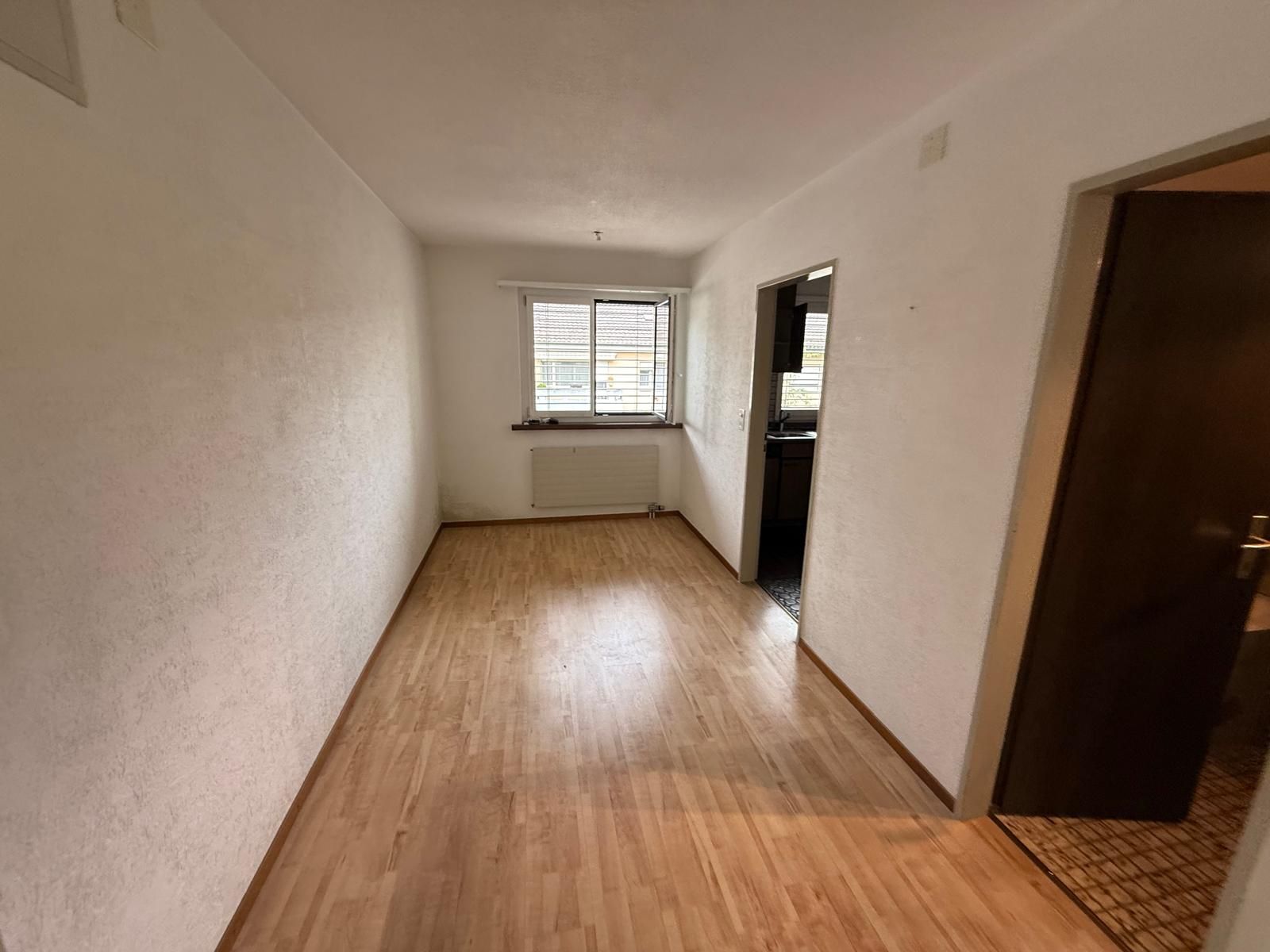 Geräumter Wohnungsflur mit Blick in die Küche
